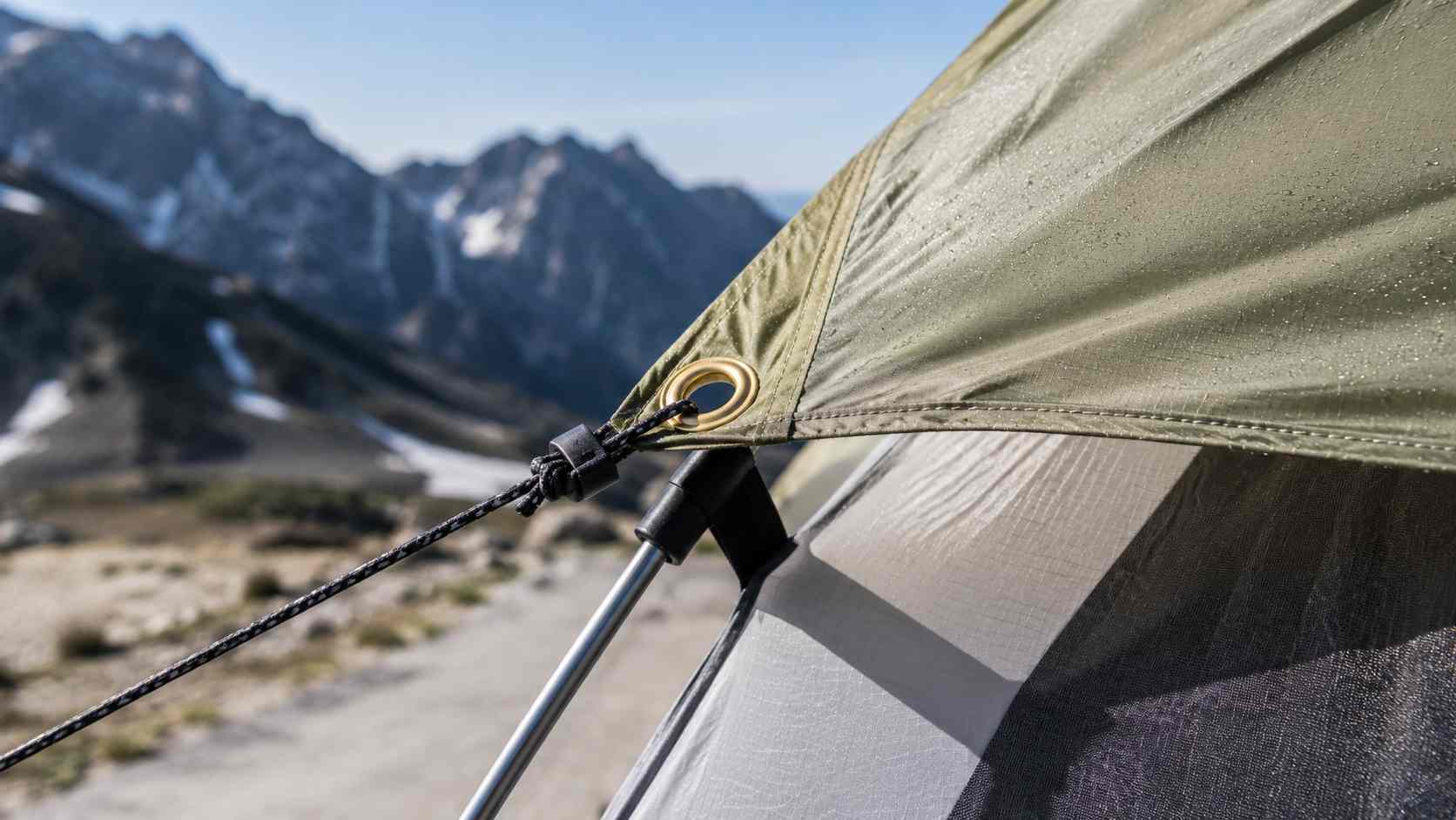 putting grommets in fabric, The image shows putting grommets in fabric at a reinforced tent corner connected to a guyline.